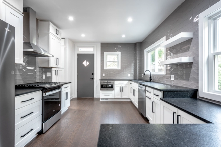 columbus-kitchen-remodel-bright-gray-cabinets-modern-backsplash Modern remodeled kitchen in Columbus featuring white cabinets, dark countertops, gray geometric backsplash, and stainless appliances as part of a featured kitchen renovation project.