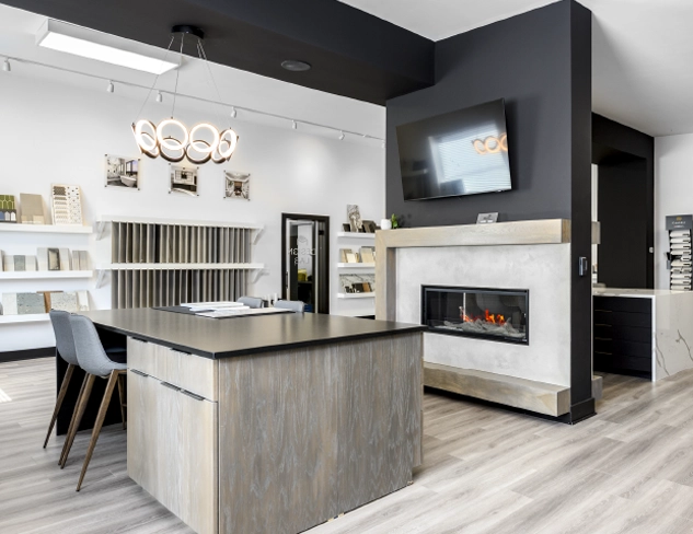 columbus-home-remodeling-showroom-design-studio Modern Columbus remodeling showroom featuring a design workstation, statement fireplace, cabinetry displays, and curated material selections for kitchen and home renovation projects.