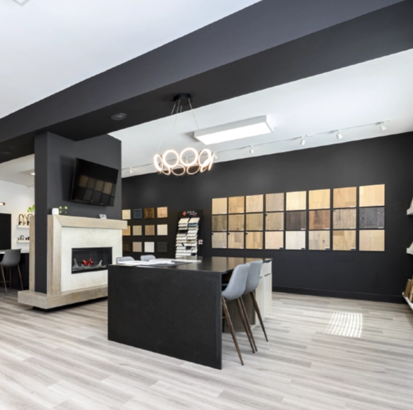 modern-home-remodeling-showroom-columbus-design-center Wide view of a modern Columbus home remodeling showroom with collaborative design workspace, fireplace, cabinetry displays, and material selection walls.